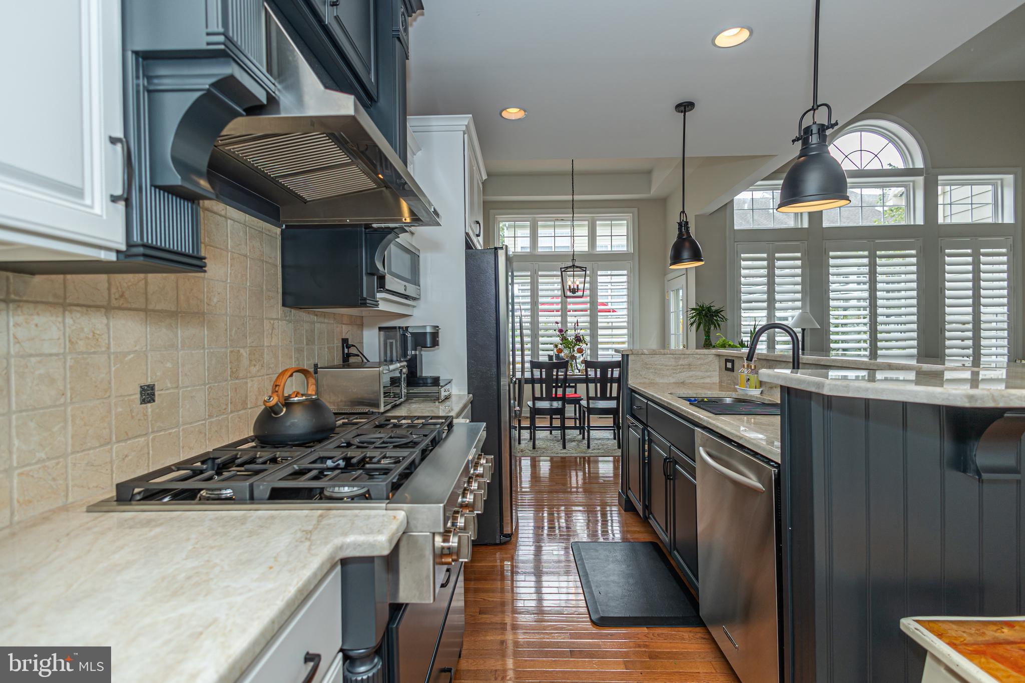 501 Titus Road Lambertville, NJ 08530 - Photo 18 of 62 a kitchen with a stove a sink a chimney wooden cabinets and a dining table