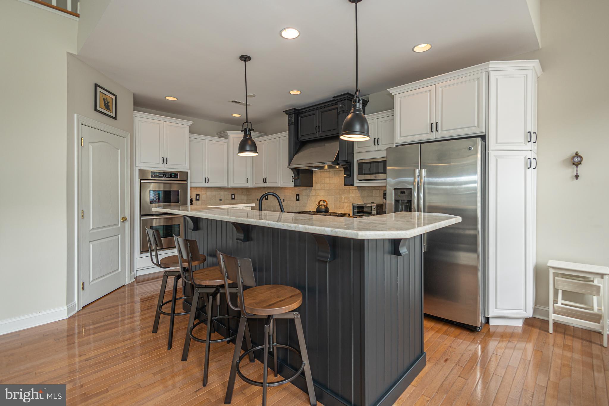 501 Titus Road Lambertville, NJ 08530 - Photo 21 of 62 a kitchen with kitchen island stainless steel appliances a dining table chairs sink and cabinets