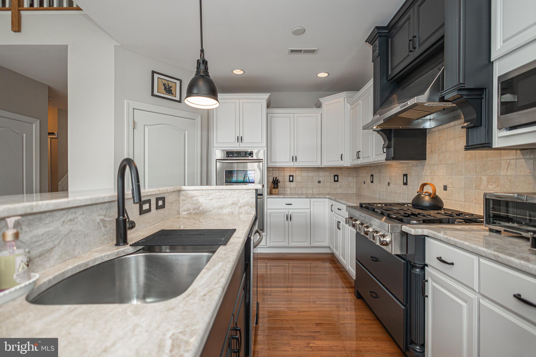 501 Titus Road Lambertville, NJ 08530 - Photo 23 of 62 a kitchen with stainless steel appliances granite countertop a sink a stove and a wooden floors