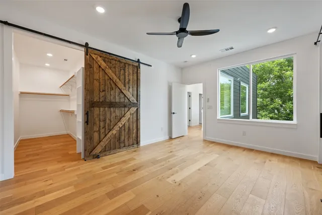a view of an empty room with glass door and windows