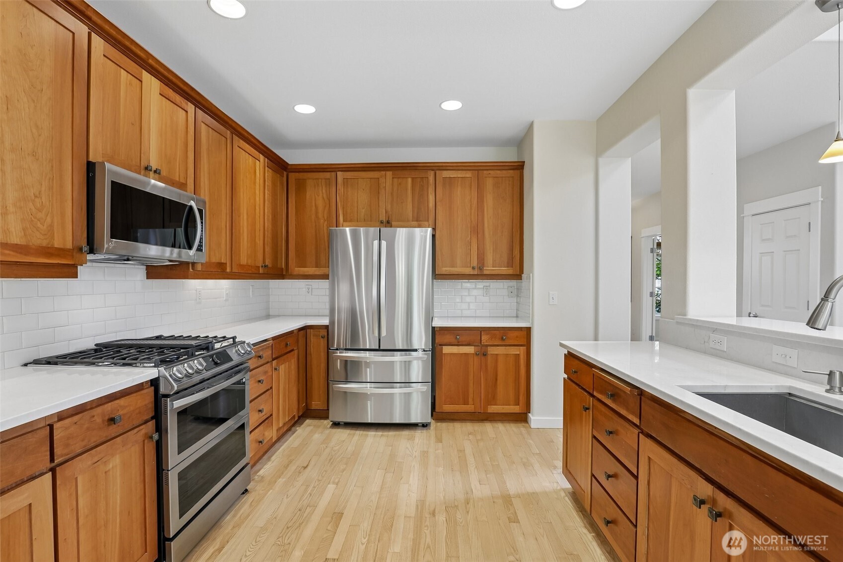 19709 Southeast 26th Way Camas, WA 98607 - Photo 7 of 36 a kitchen with granite countertop a refrigerator a stove top oven a sink and dishwasher