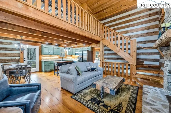 a dining room with furniture a chandelier and wooden floor