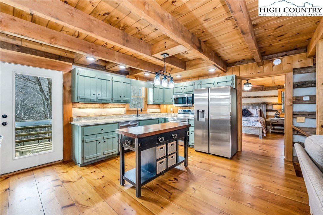 372 Homestead Road Todd, NC 28684 - Photo 20 of 41 a kitchen with stainless steel appliances granite countertop a table chairs and wooden floors