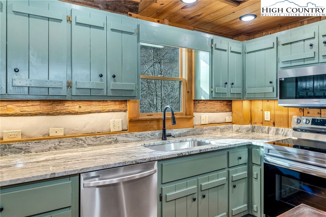 372 Homestead Road Todd, NC 28684 - Photo 22 of 41 a kitchen with stainless steel appliances granite countertop a sink a stove and cabinets