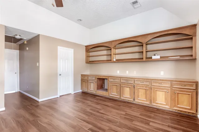 a view of a livingroom with wooden floor and a ceiling fan