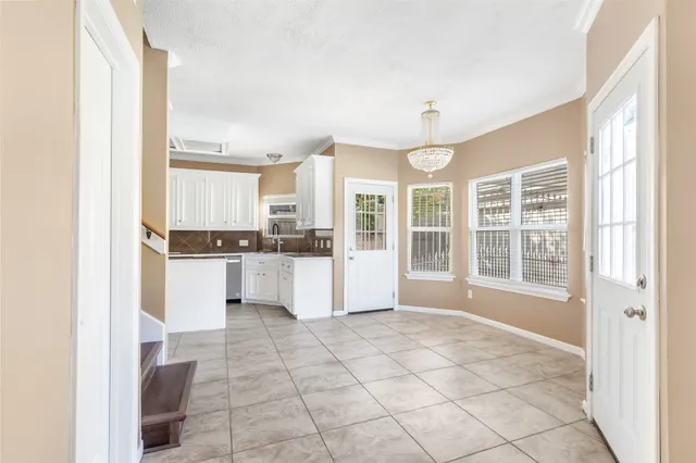 a view of kitchen with windows and refrigerator