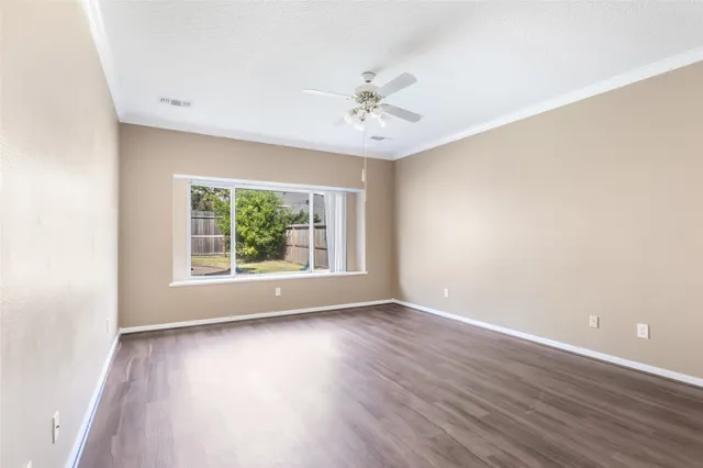 a view of an empty room with wooden floor