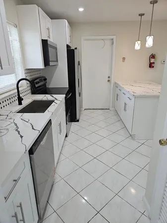 a view of a kitchen with sink washer and dryer