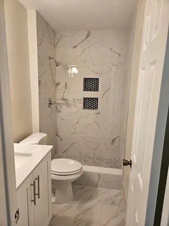 a bathroom with a toilet a sink and shower