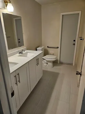 a bathroom with a sink and mirror with toilet