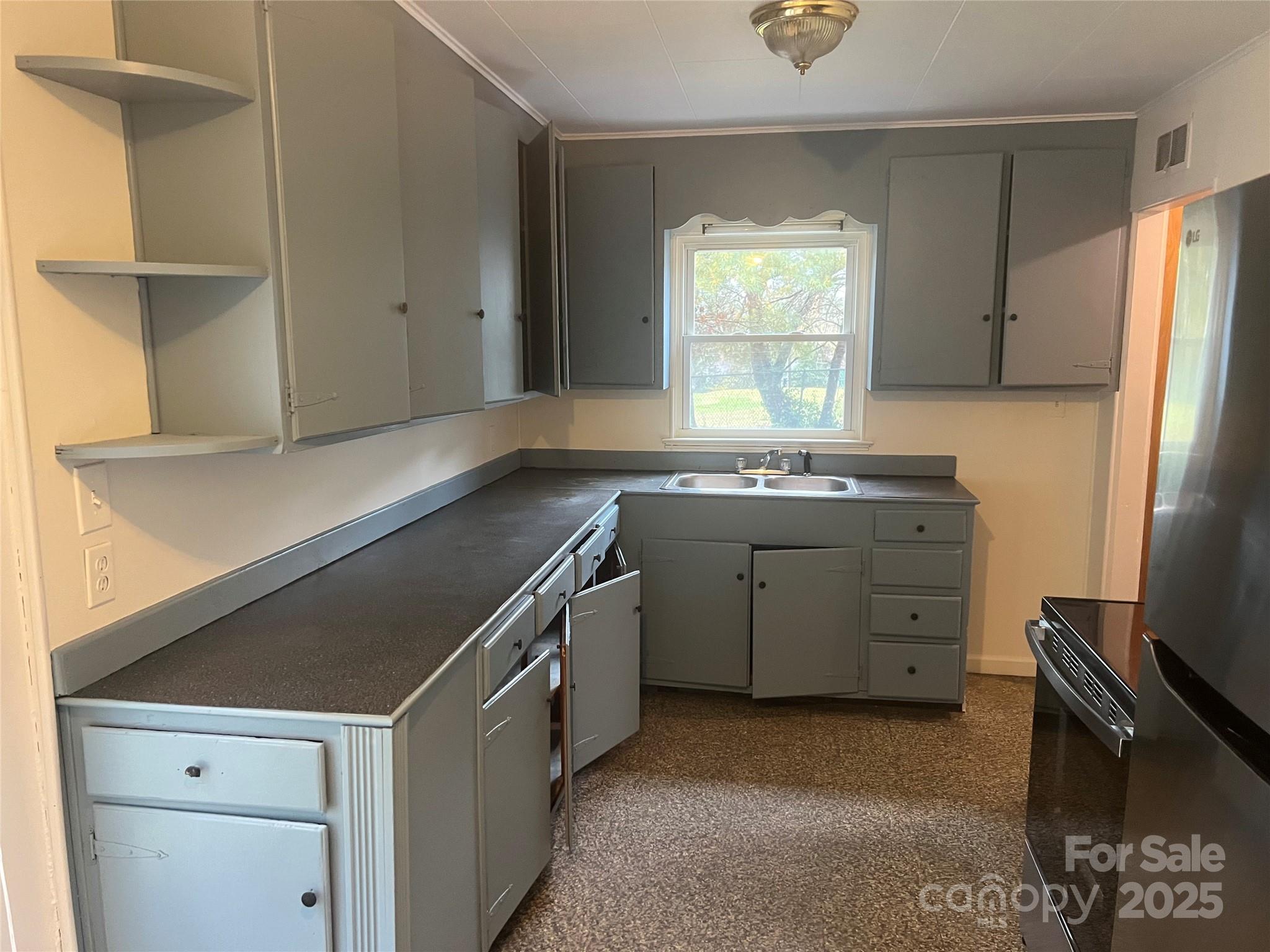 243 Governors View Road Asheville, NC 28805 - Photo 5 of 17 a kitchen with a sink cabinets stainless steel appliances and a window