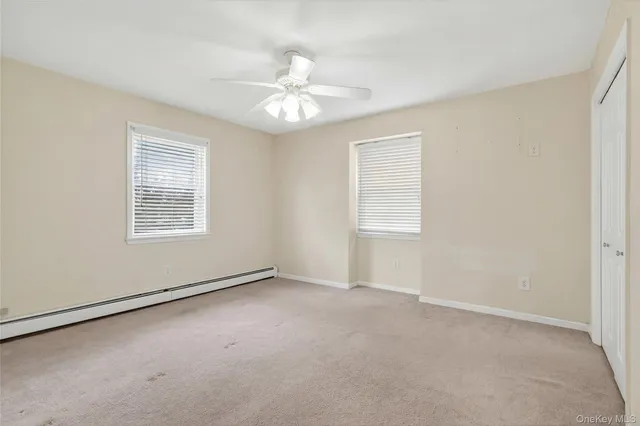 a view of an empty room with wooden floor and sliding glass door