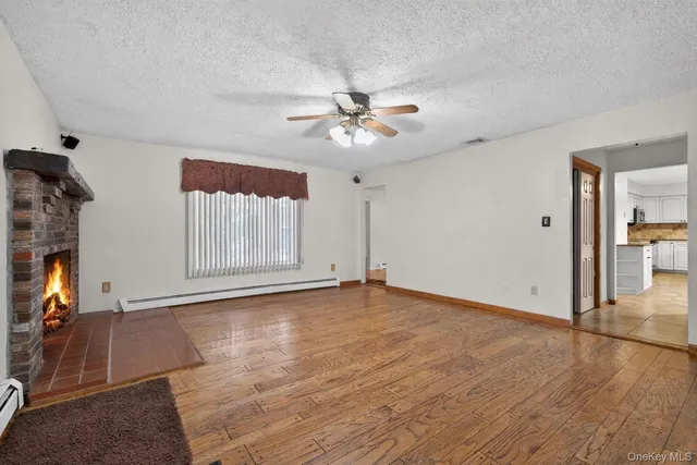 a large kitchen with kitchen island a stove a sink dishwasher and white cabinets with wooden floor