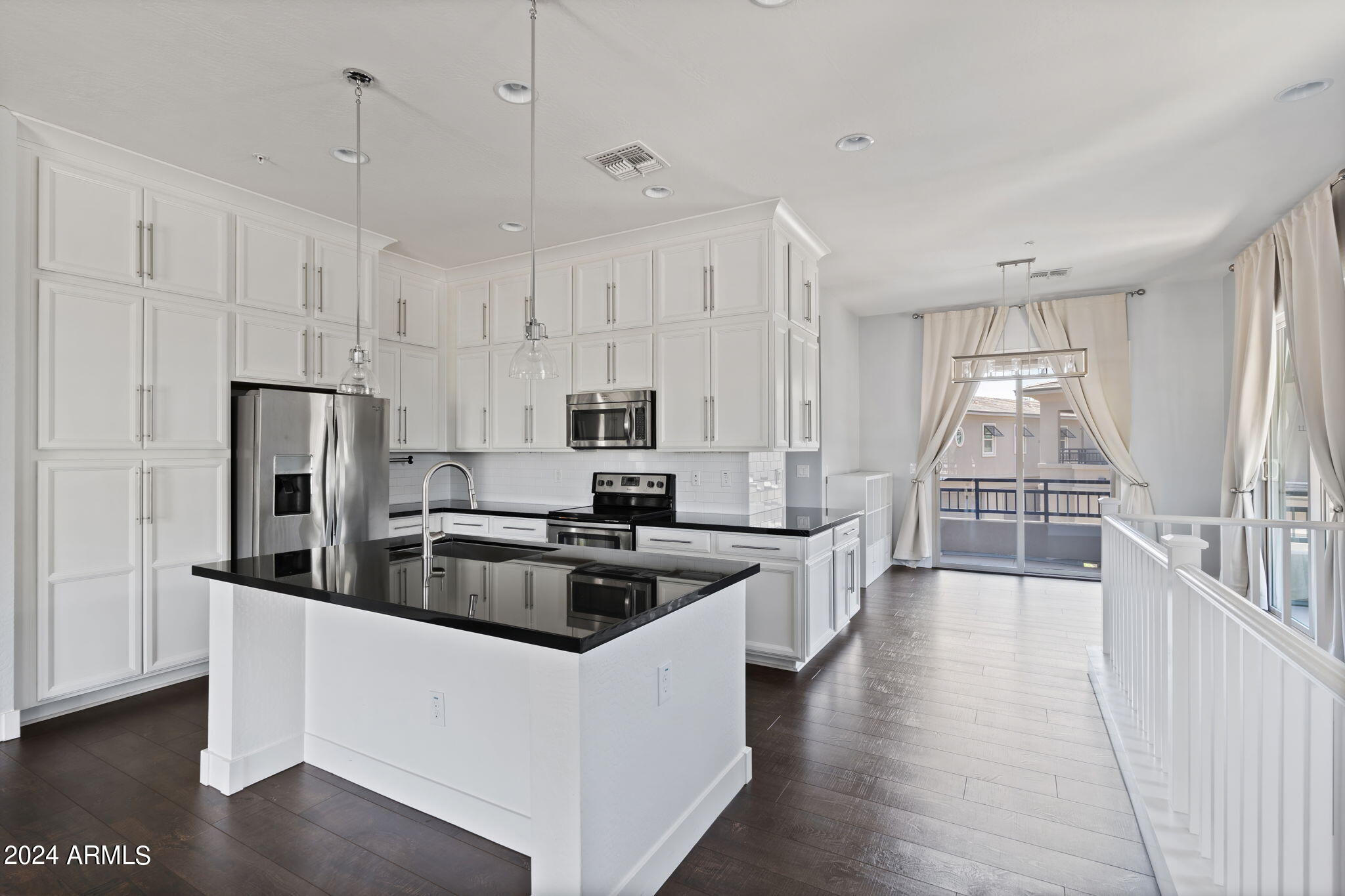 a kitchen that has a lot of cabinets and wooden floor