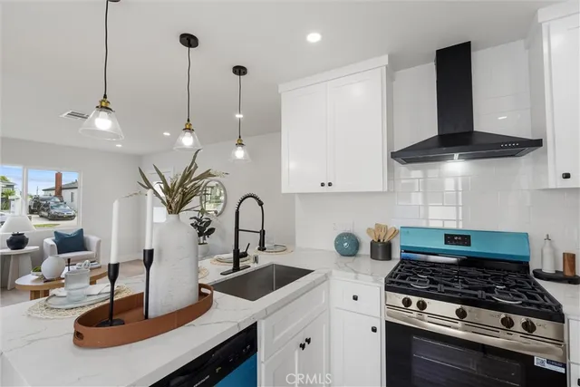 a kitchen with kitchen island a stove and a sink with granite countertops