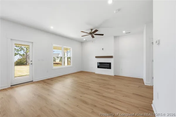 a kitchen with stainless steel appliances granite countertop a sink a stove a refrigerator and white cabinets