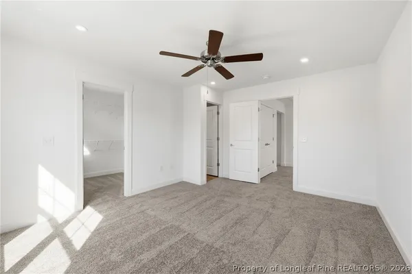 an empty room with closet and windows