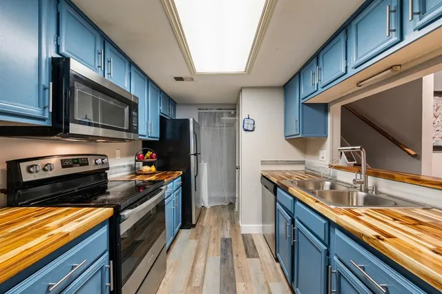 a kitchen with stainless steel appliances granite countertop a sink a stove and cabinets
