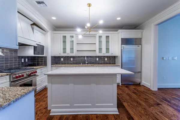 a kitchen with stainless steel appliances granite countertop a stove a sink and a refrigerator