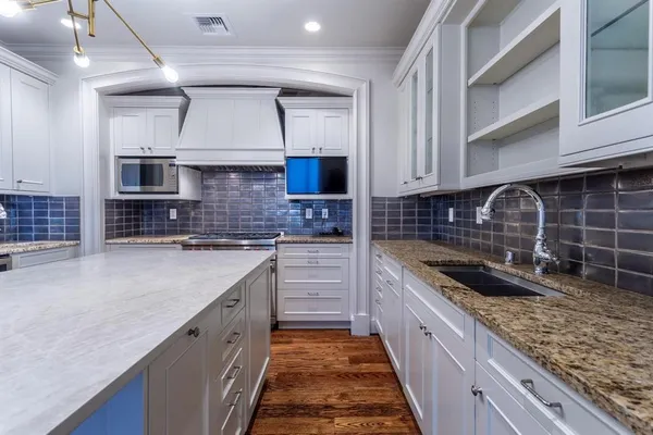 a kitchen with stainless steel appliances granite countertop a sink and a stove