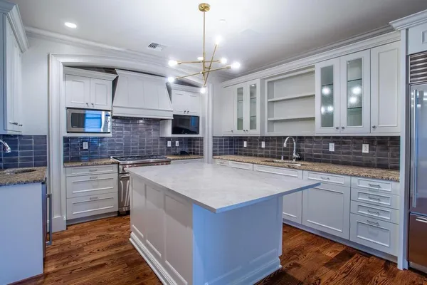 a kitchen with stainless steel appliances granite countertop a sink stove and cabinets