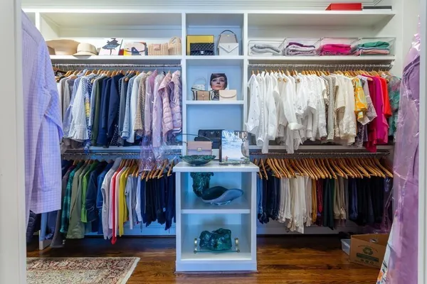 a view of walk in closet with clothes and shoes