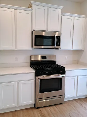 a kitchen with white cabinets and stainless steel appliances