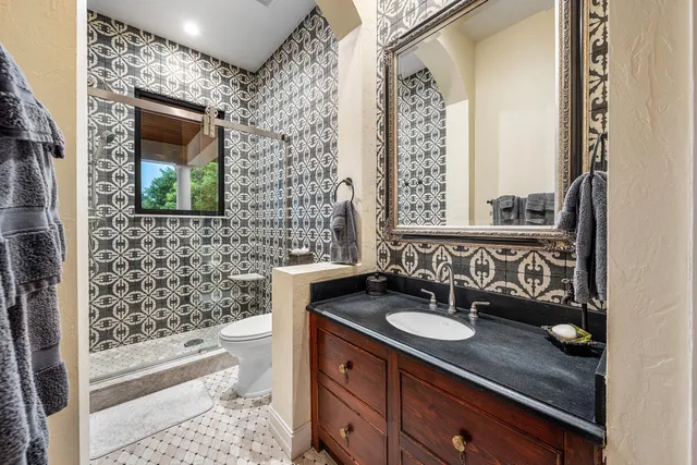 a view of a swimming pool with a table and chairs under palm trees