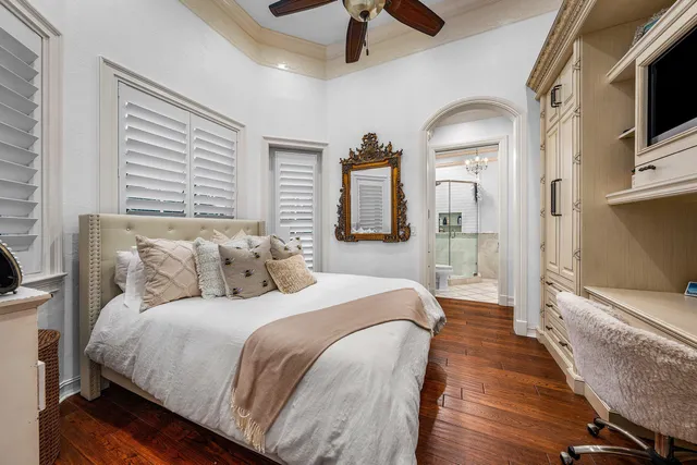 a view of a swimming pool with a table and chairs under palm trees