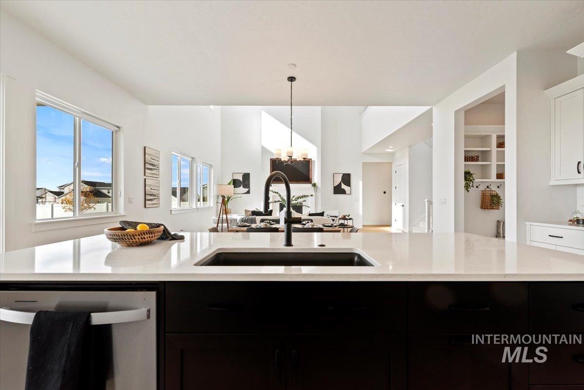 14701 Port Royal Street Caldwell, ID 83607 - Photo 39 of 40 Kitchen with stainless steel dishwasher, dark cabinetry, open floor plan, and pendant lighting