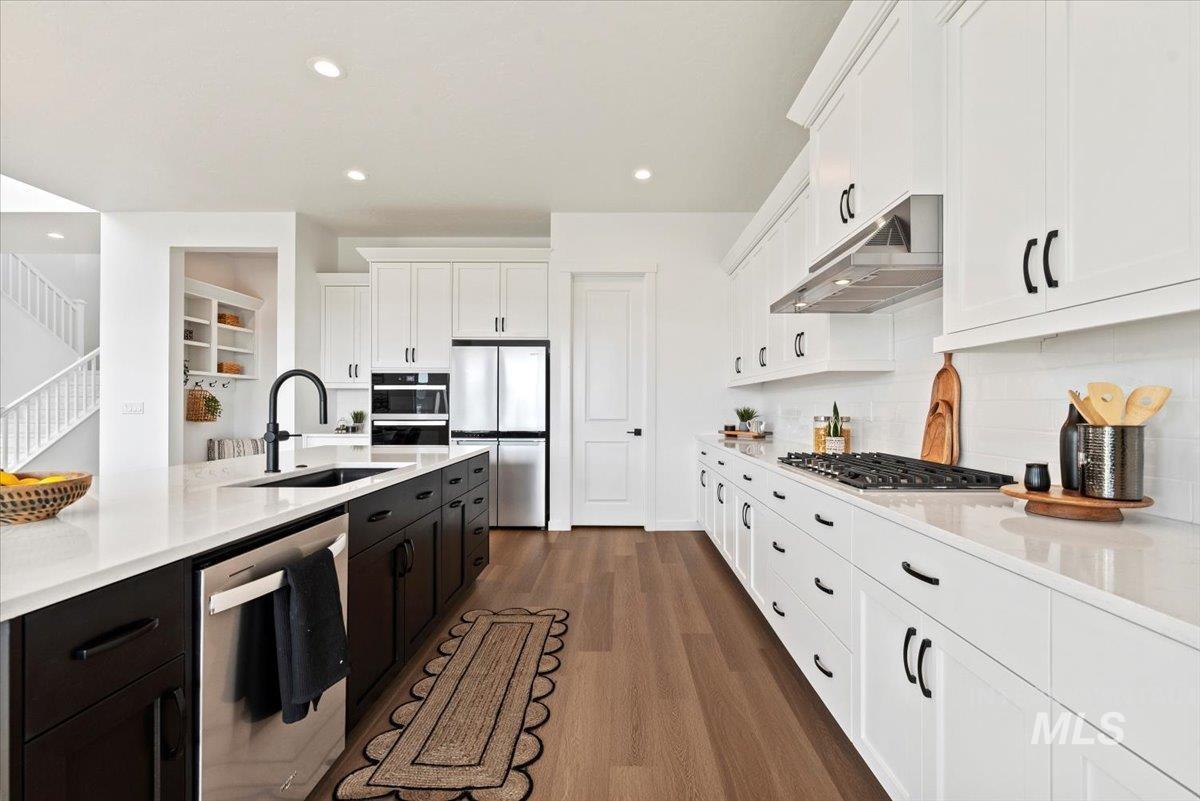 14701 Port Royal Street Caldwell, ID 83607 - Photo 12 of 40 Kitchen with white cabinetry, stainless steel appliances, dark wood-type flooring, light stone counters, and recessed lighting
