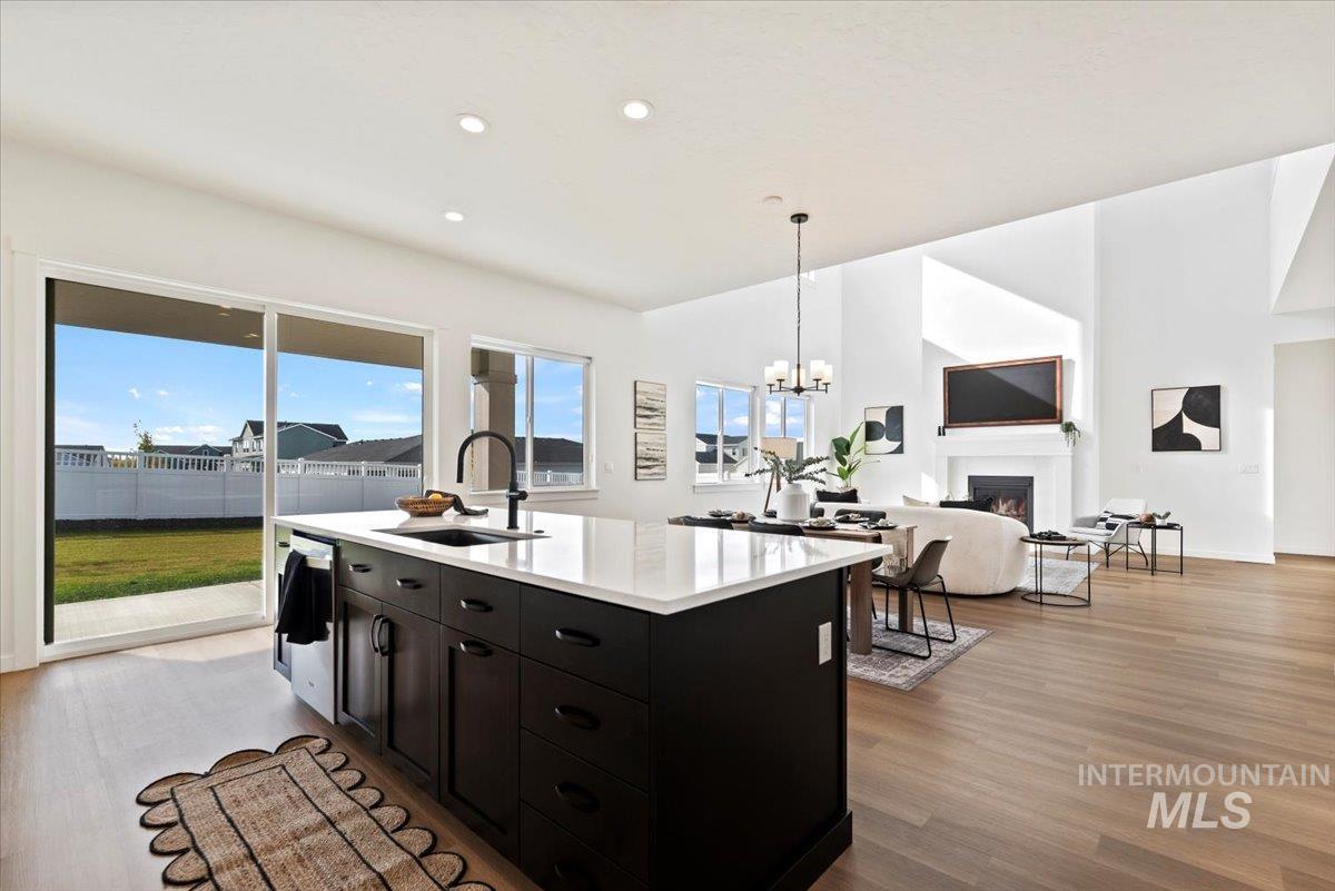 14701 Port Royal Street Caldwell, ID 83607 - Photo 40 of 40 Kitchen featuring a warm lit fireplace, decorative light fixtures, dark wood-style floors, open floor plan, and recessed lighting