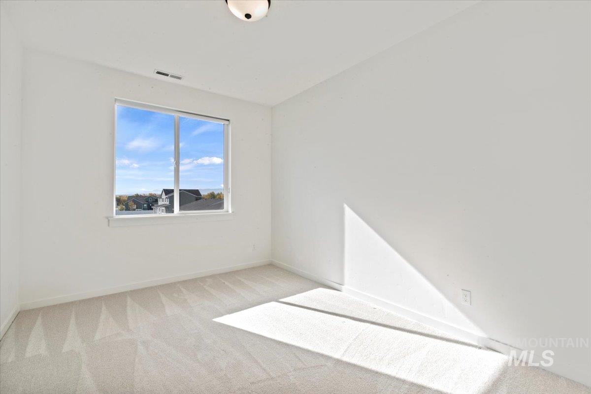 14701 Port Royal Street Caldwell, ID 83607 - Photo 24 of 40 Empty room with light colored carpet and baseboards