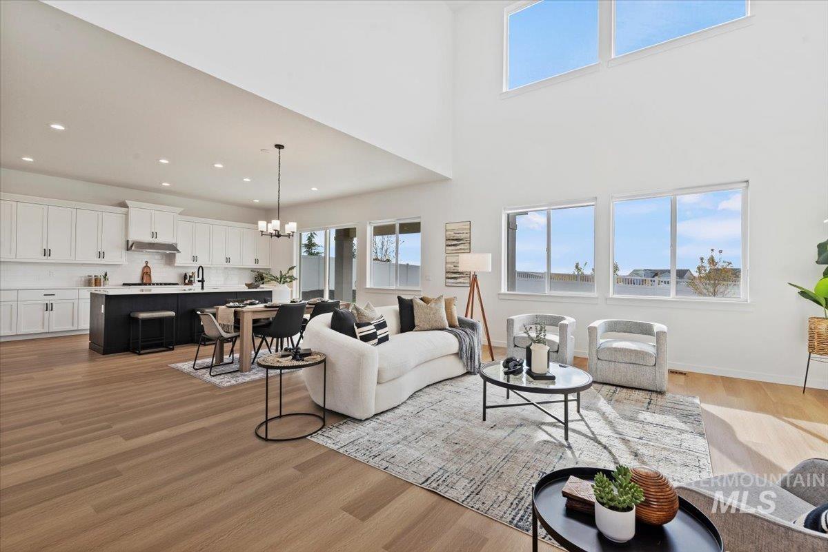 14701 Port Royal Street Caldwell, ID 83607 - Photo 7 of 40 Living room featuring a chandelier, a towering ceiling, light wood finished floors, and recessed lighting