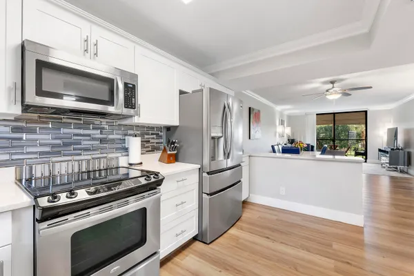 a kitchen with stainless steel appliances white cabinets a stove top oven a sink and dishwasher