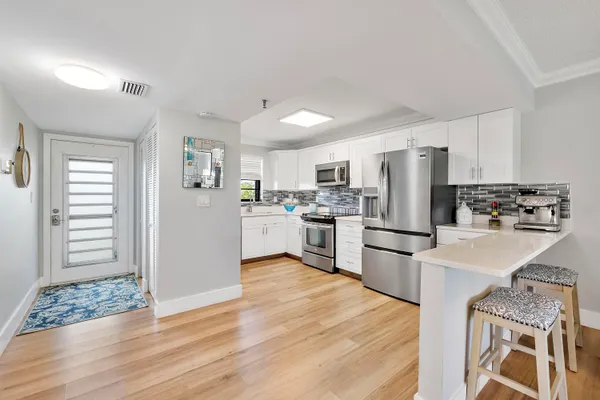 a kitchen with white cabinets and stainless steel appliances