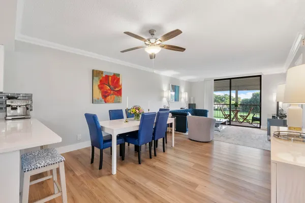 a dining room with furniture a chandelier and wooden floor