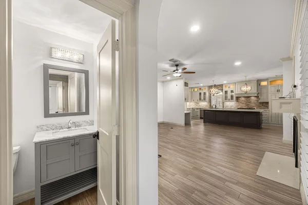 an empty room with wooden floor ceiling fan and windows