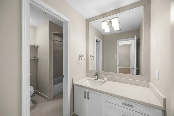 an empty room with wooden floor and ceiling fan