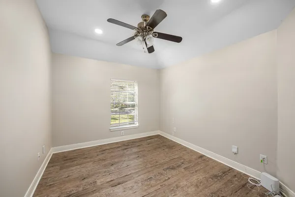 an empty room with windows and fan