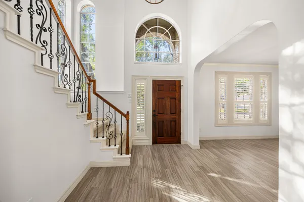 an empty room with wooden floor and fireplace