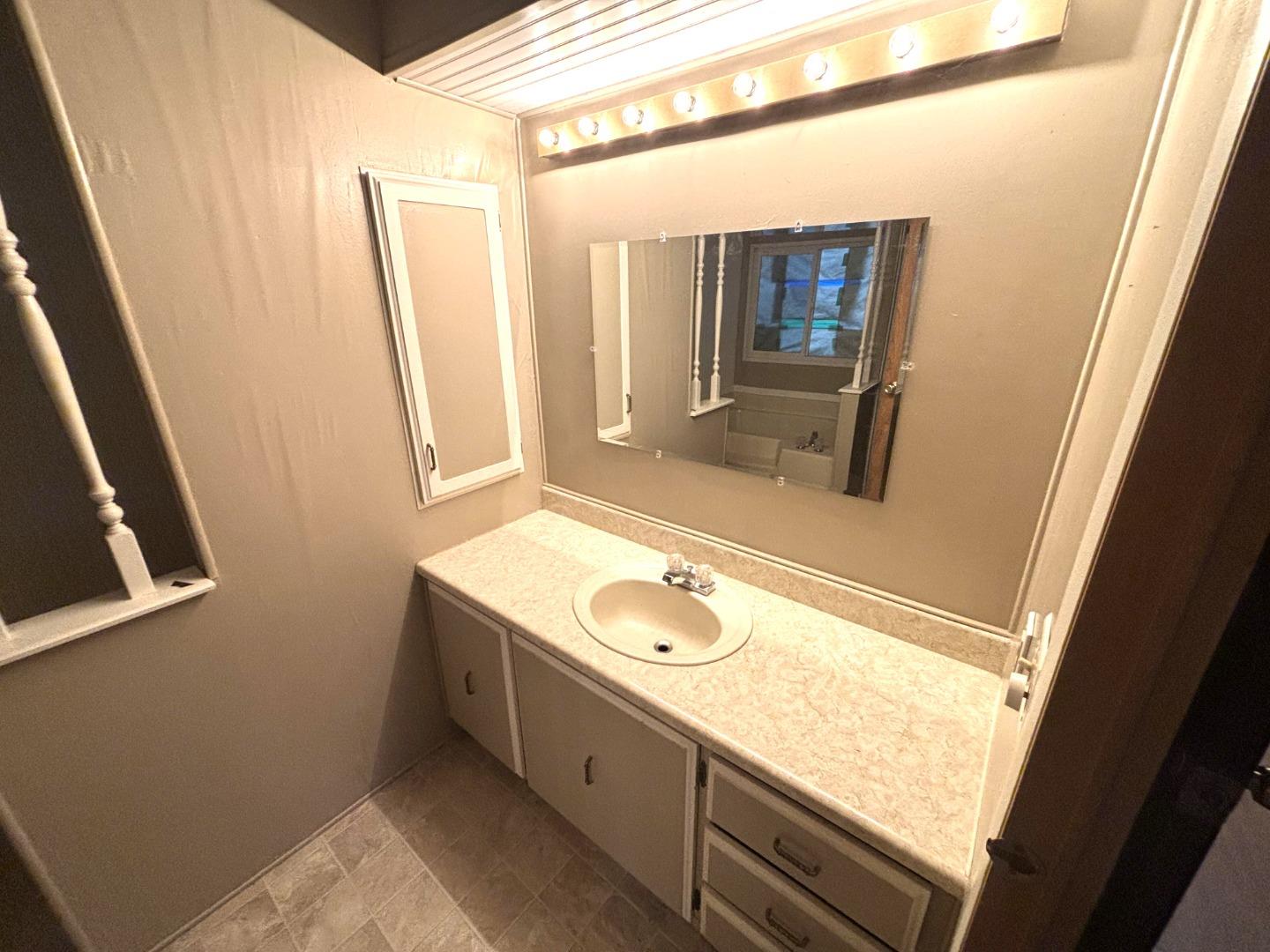 3156 Esplanade, Unit 304 Chico, CA 95973 - Photo 13 of 30 a bathroom with a granite countertop sink and a large mirror