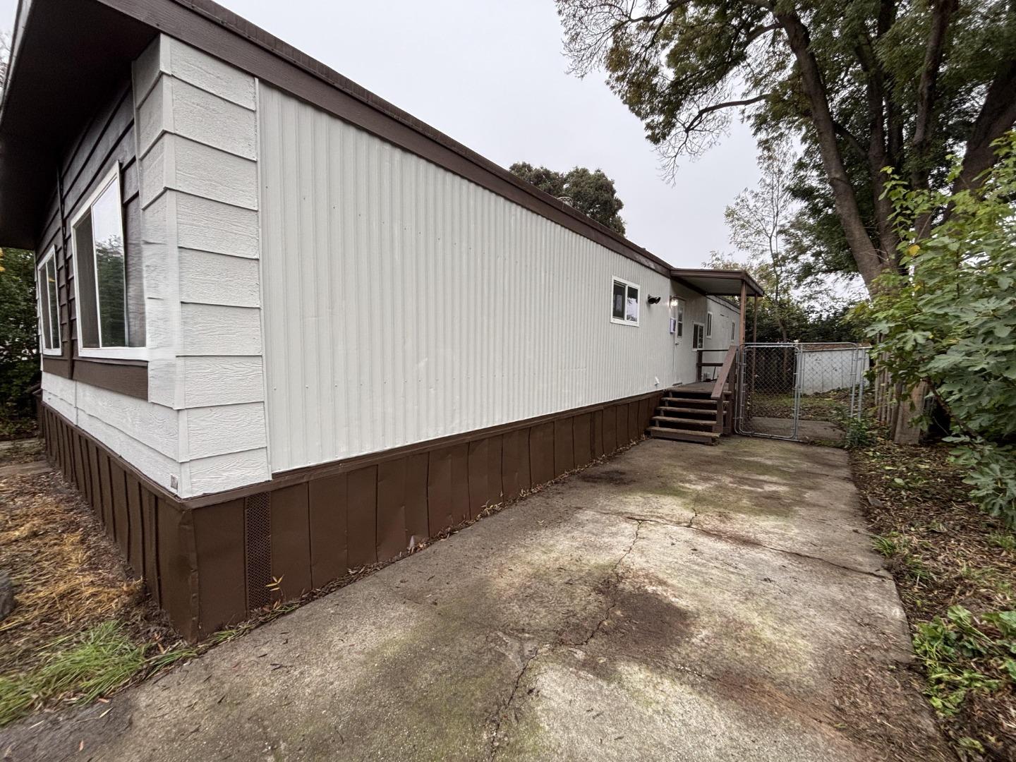 3156 Esplanade, Unit 304 Chico, CA 95973 - Photo 30 of 30 a view of a house with wooden fence and two of trees