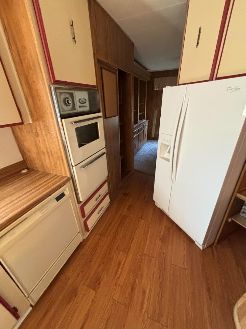 3156 Esplanade, Unit 304 Chico, CA 95973 - Photo 5 of 30 a view of a kitchen with wooden floor and electronic appliances