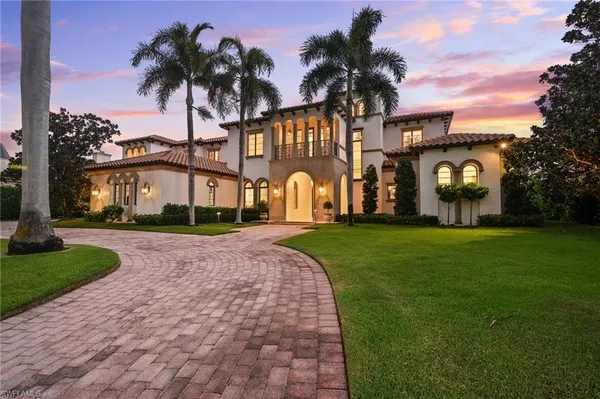 a front view of multi story residential apartment building with yard and green space