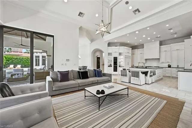 a living room with lots of furniture and view of kitchen