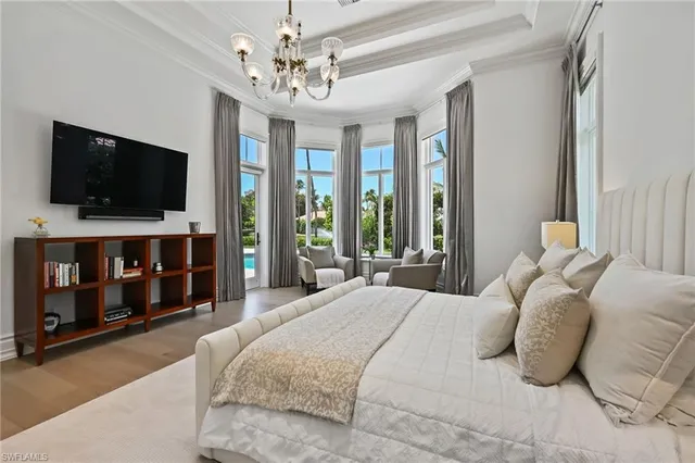 a bedroom with a bed a flat screen tv and a window