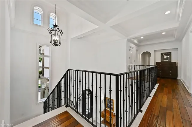 a view of staircase with railing and a chandelier