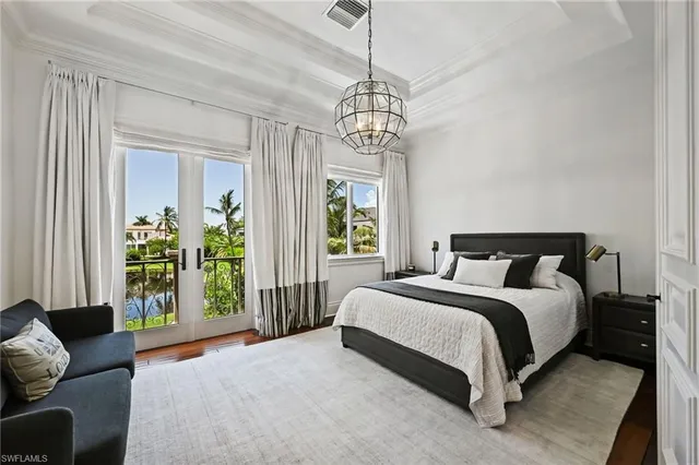 a spacious bedroom with a bed and a chandelier