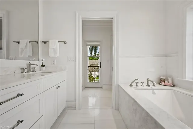 a spacious bathroom with a tub sink and mirror